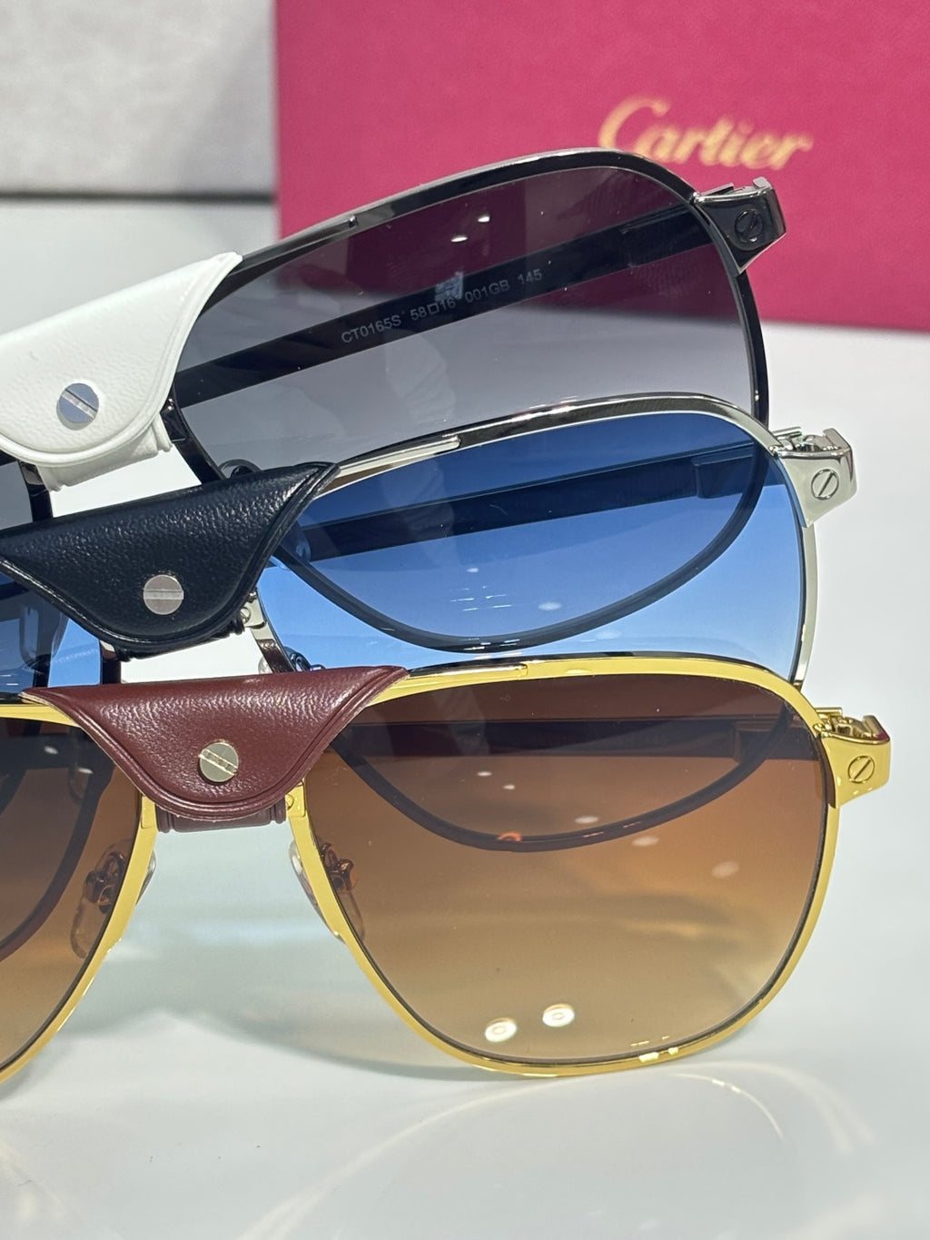 Sunglasses close-up: blue-tinted dark frames and gold-tinted frames, side view