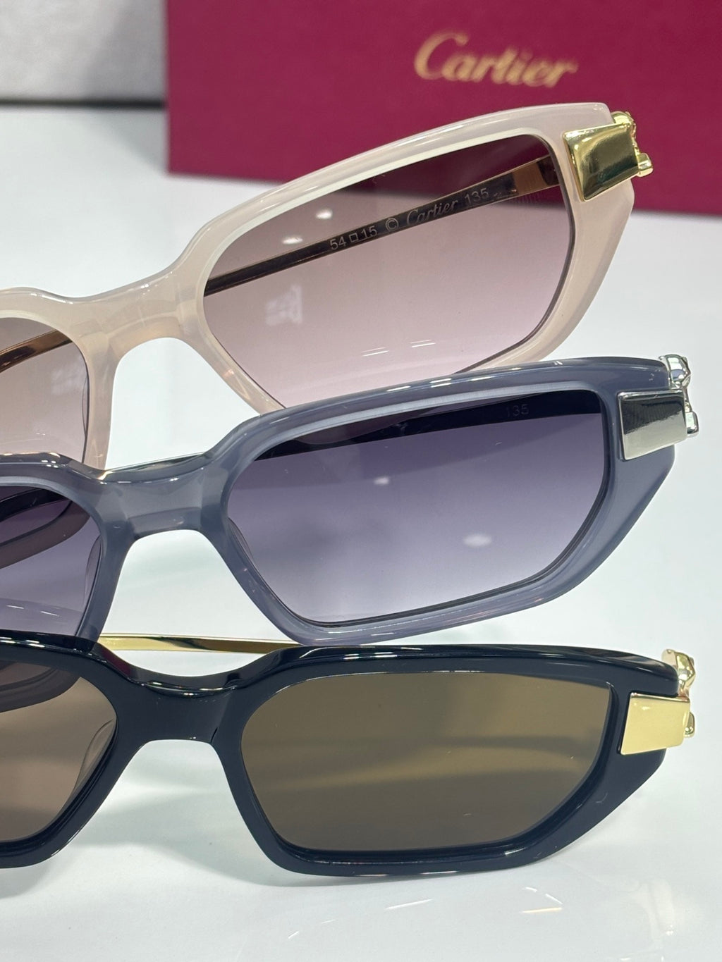 Cartier eyeglasses close-up: beige, navy, and black frames with pink and dark lenses