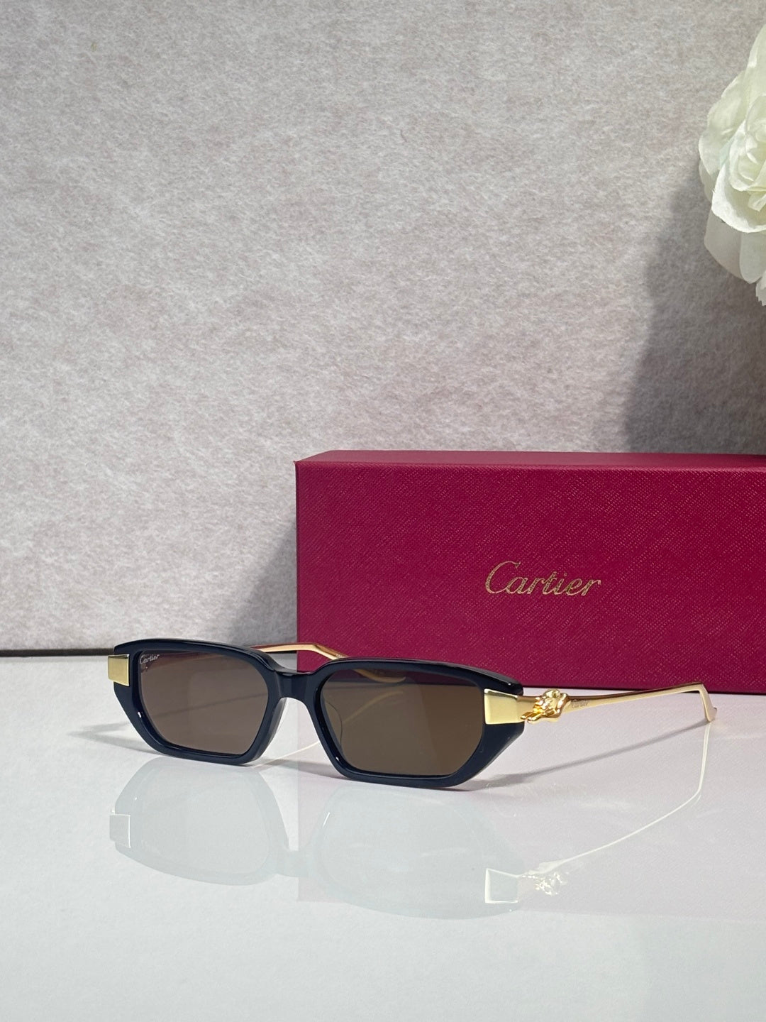 Cartier eyeglasses with dark blue frames, brown lenses, and gold-tone hinge embellishments