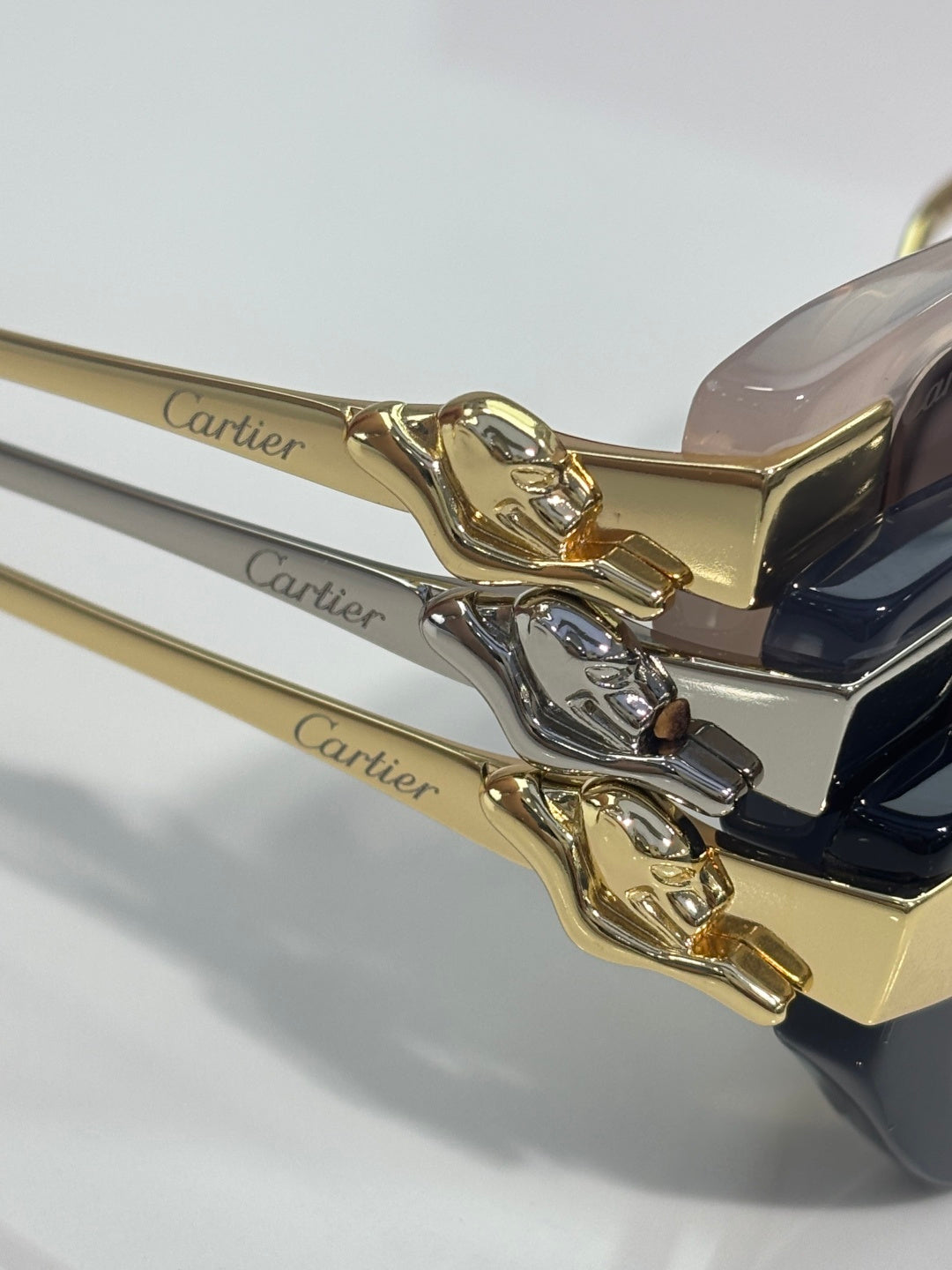 Close-up of Cartier eyeglasses: gold-tone cat head ornament and gold temple arm
