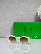 Bottega Veneta sunglasses with light frame and gold-tone temples, brown lenses