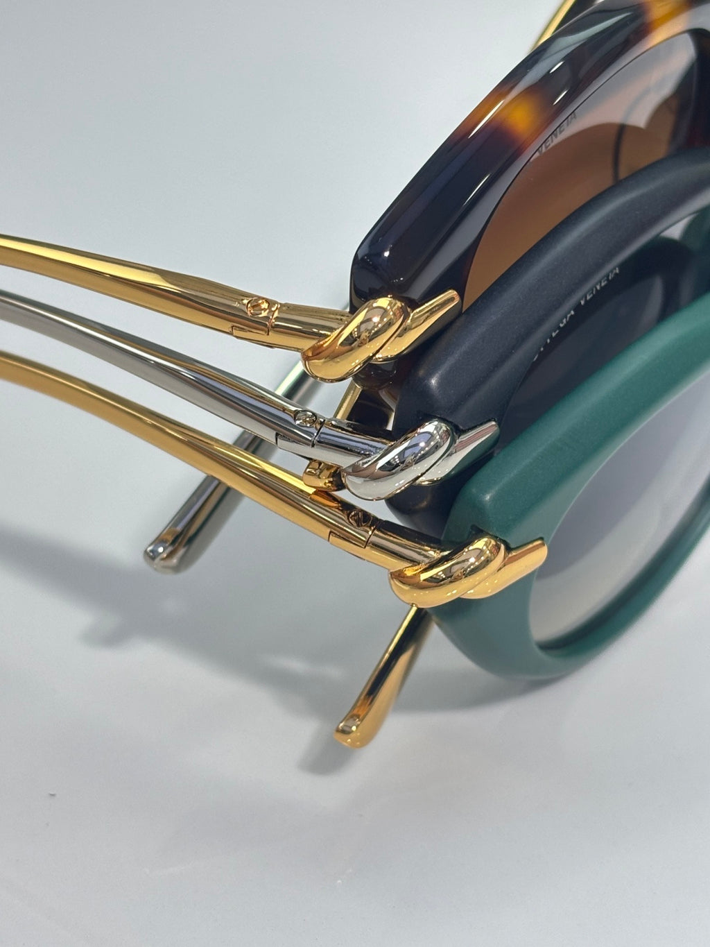 Bottega Veneta sunglasses close-up of gold-tone hinge and striped temple details