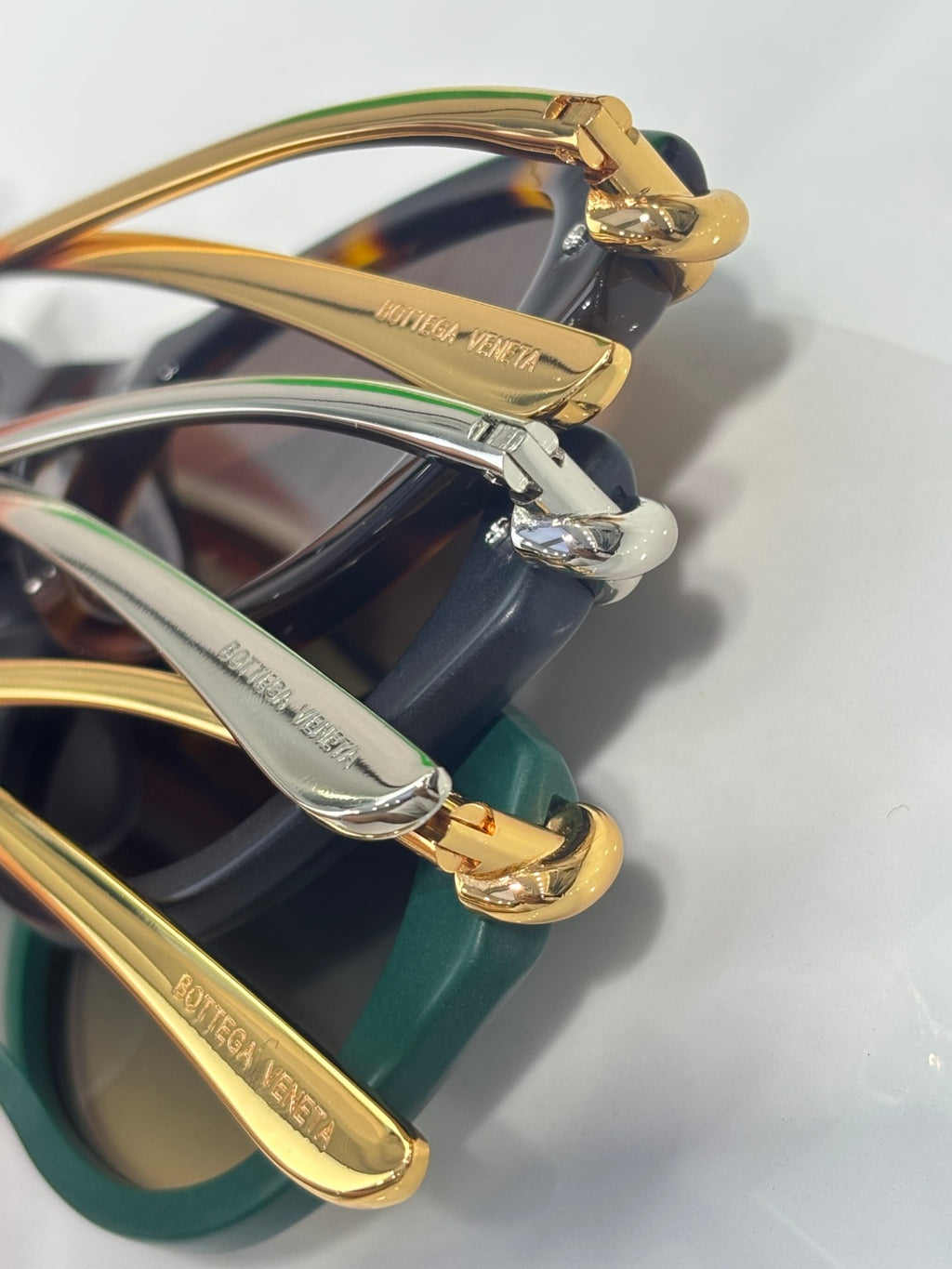 Bottega Veneta sunglasses close-up of gold-tone hinge on mixed-color frames