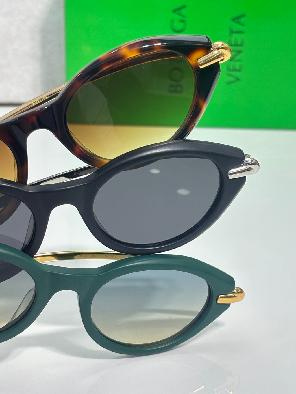 Bottega Veneta sunglasses close-up of tortoise and black frames with gold-tone hinge