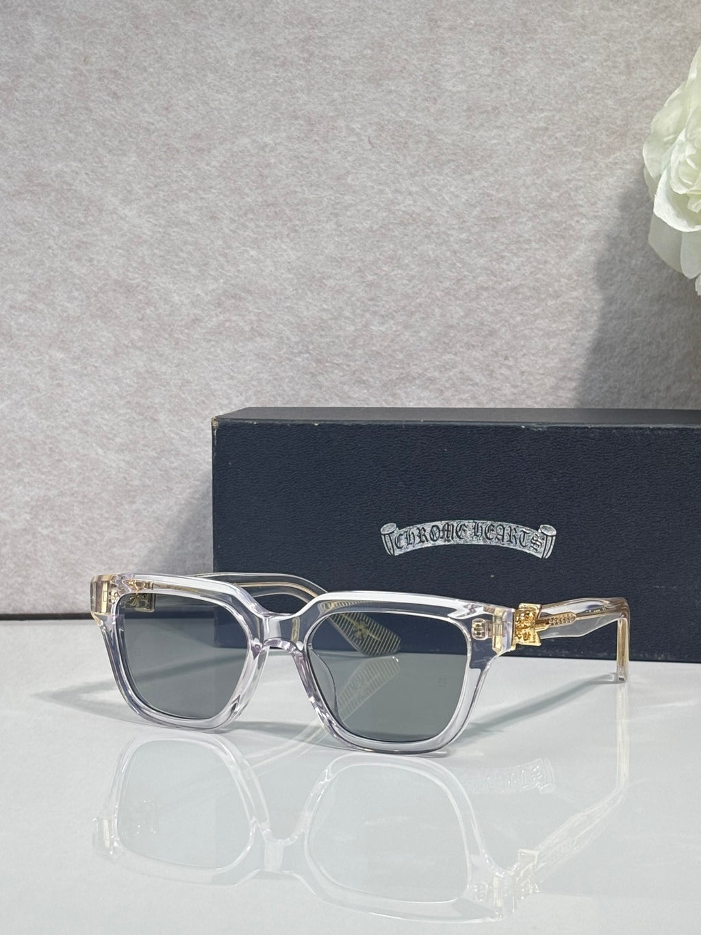 Silver rectangular sunglasses with dark lenses and gold hinge ornament