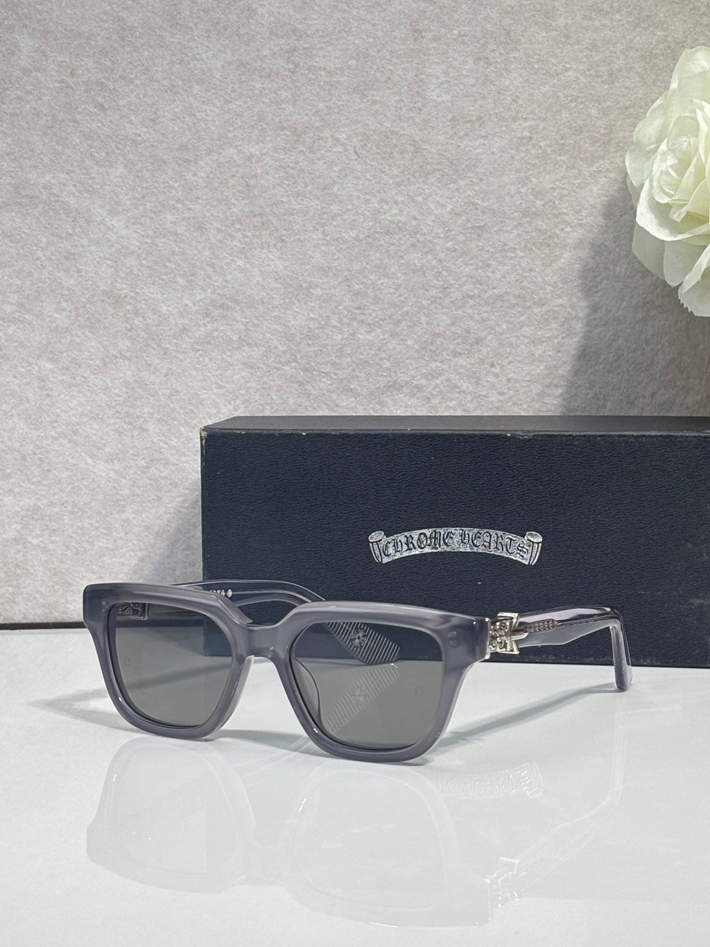 Clear-gray square sunglasses with dark lenses and gold hinge detail