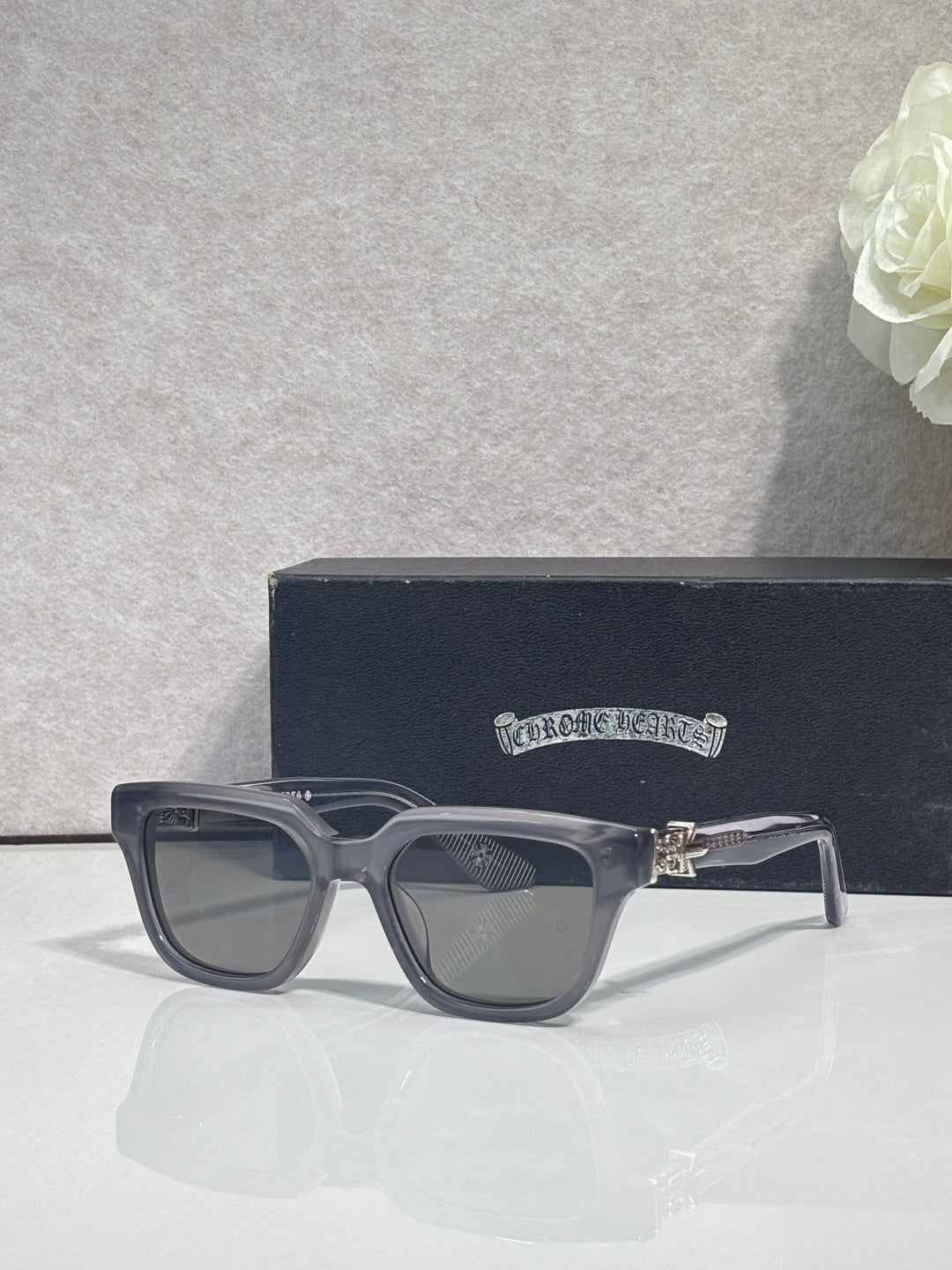 Clear-gray square sunglasses with dark lenses and gold hinge detail
