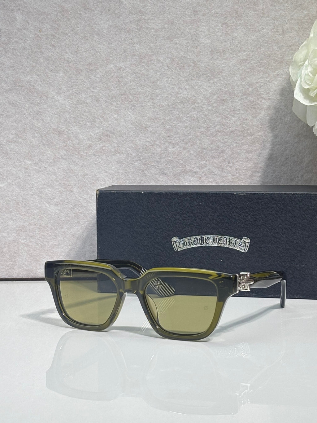 Olive green square sunglasses with amber-tinted lenses and gold accents