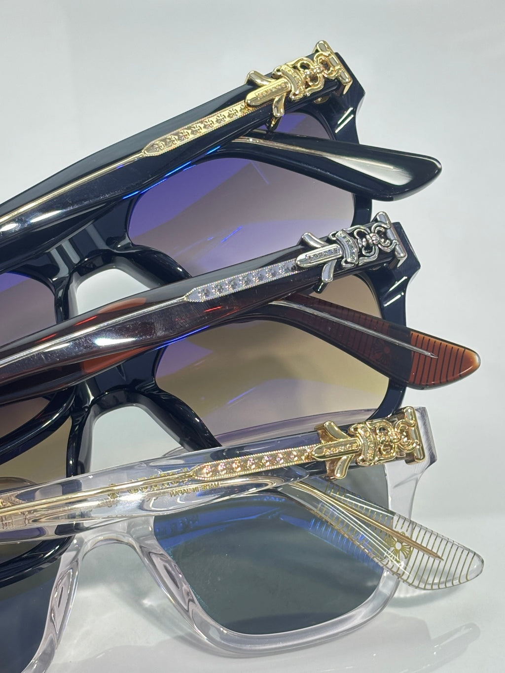 Navy blue and clear sunglasses with gold decorative temple hinges
