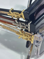 Blue glasses with gold ornamental hinges and clear lenses