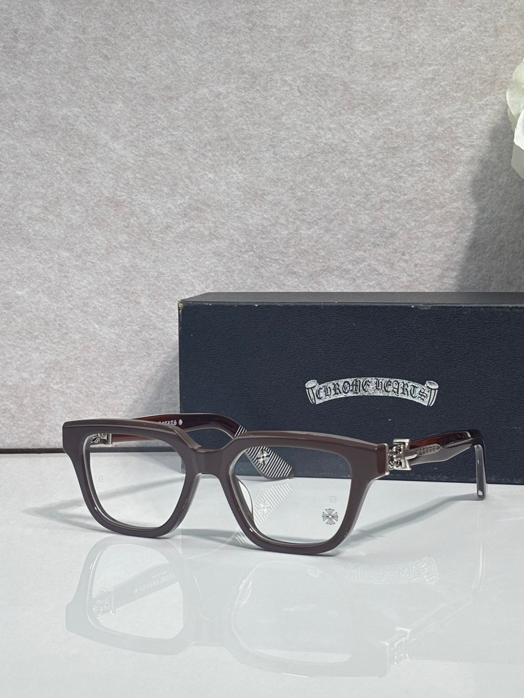 Brown full-rim eyeglasses with clear lenses and gold-tone hinge detail