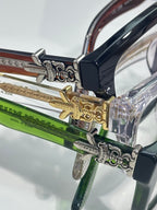 Close-up of eyeglass hinge with ornate silver and gold metal details