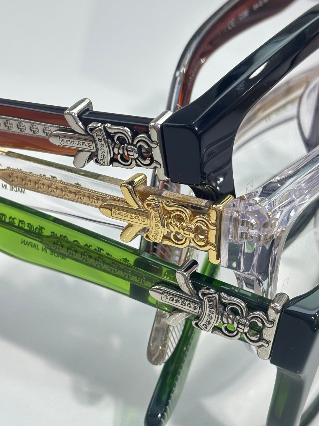 Close-up of eyeglass hinge with ornate silver and gold metal details