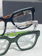Close-up of eyeglass frames with clear lenses, green and navy accents