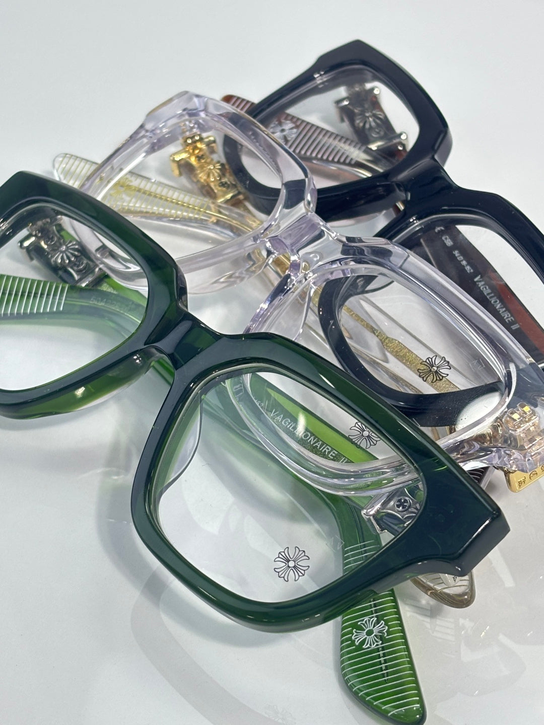 Green eyeglasses with square frames and clear lenses, metal temples