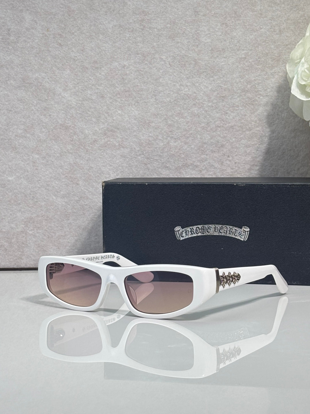 Chrome glasses with white frames and light-tinted lenses, with star metal accents on temples.