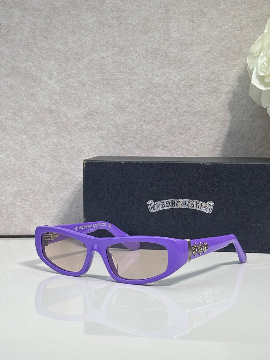 Chrome glasses with purple frames and clear lenses, with star-style metal details on temples.