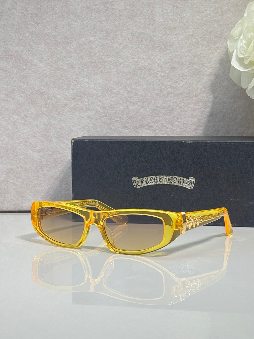 Chrome glasses with yellow frames and clear lenses, featuring gold star details on temples.