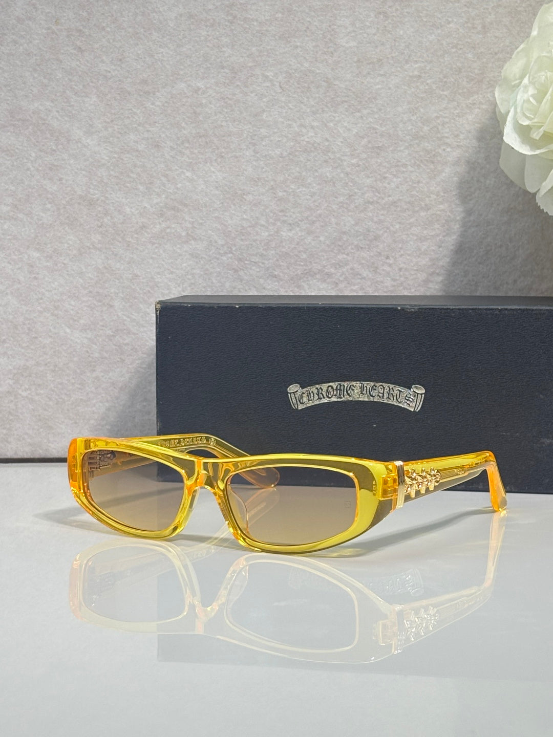 Chrome glasses with yellow frames and clear lenses, featuring gold star details on temples.