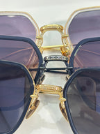 Stacked sunglasses close-up with gold and blue frames and dark tinted lenses