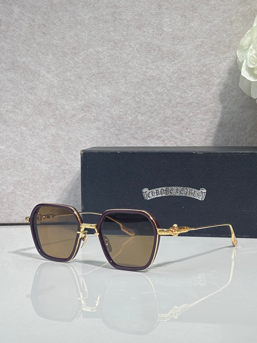 Gold-rim square sunglasses with dark lenses, brown frame, and ornate hinge detail