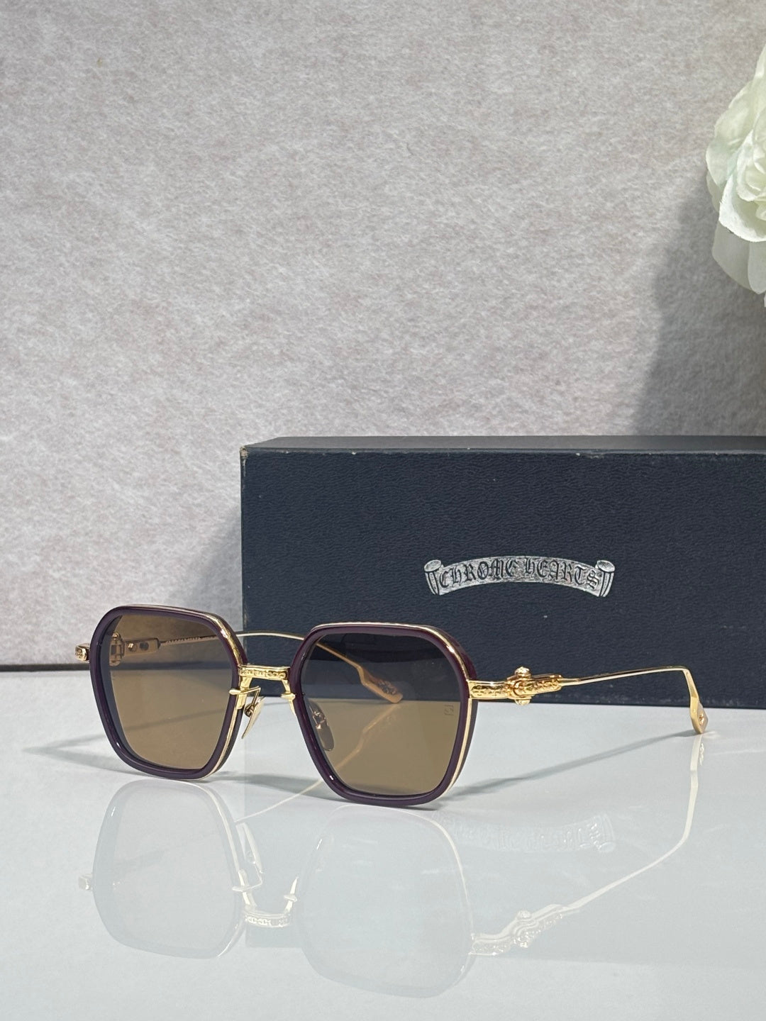 Gold-rim square sunglasses with dark lenses, brown frame, and ornate hinge detail