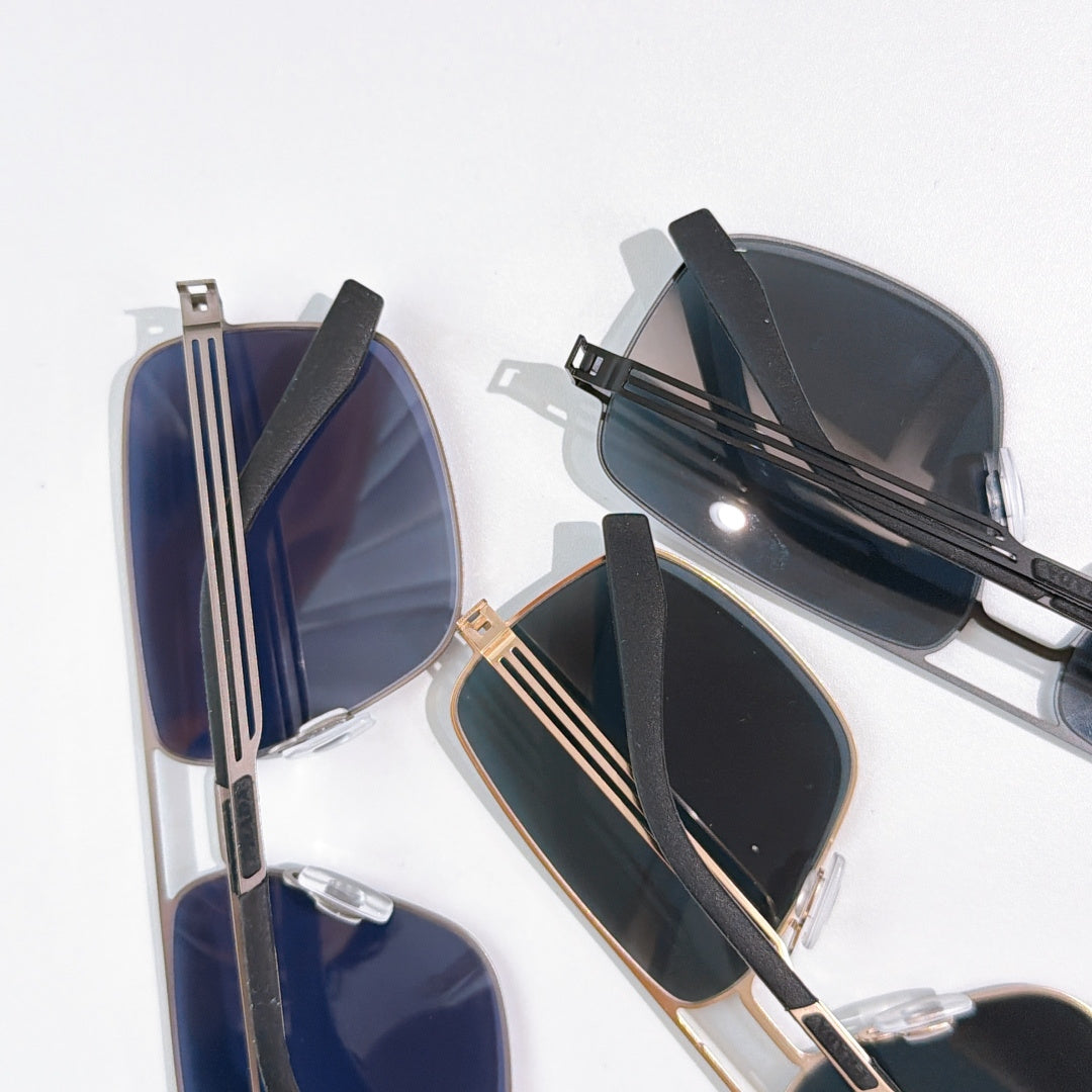Prada sunglasses pair with dark lenses and gold-tone frames, stacked view
