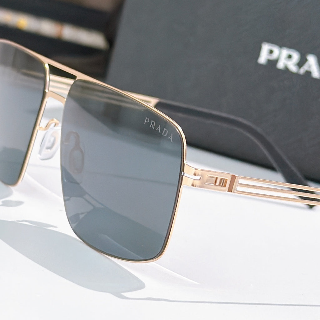 Prada sunglasses close-up of gold-tone frame and dark-tinted lens