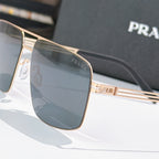 Prada sunglasses close-up of gold-tone frame and dark-tinted lens