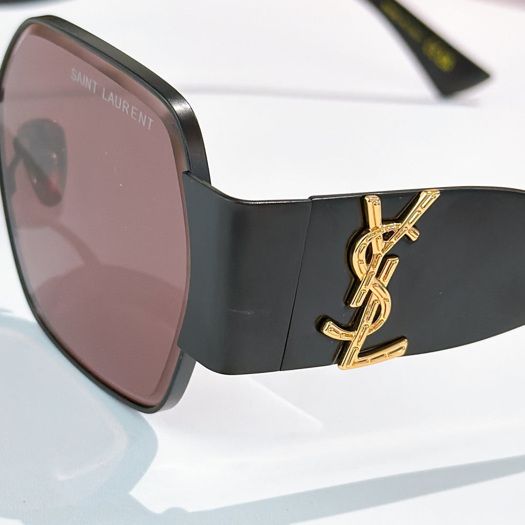 Black sunglasses with rosy tinted lenses and gold YSL-style side logo