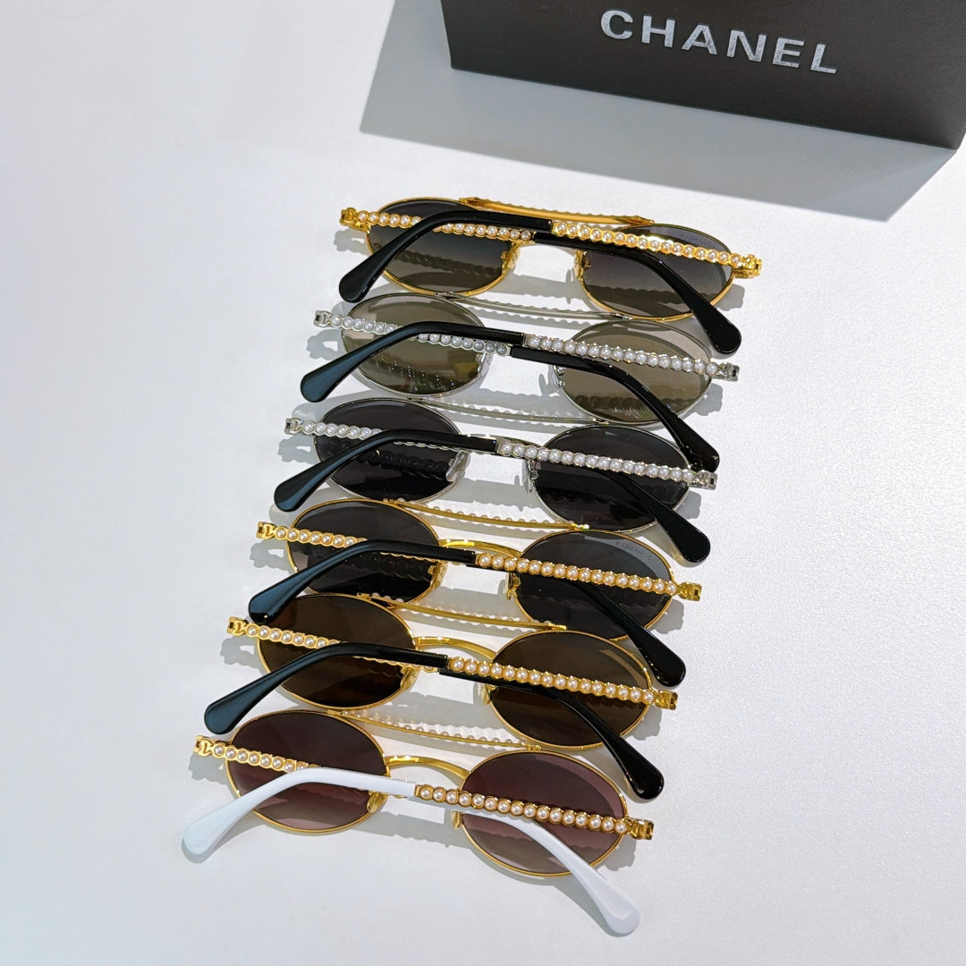 Assorted round sunglasses stack with black and gold frames and pearl temple chains