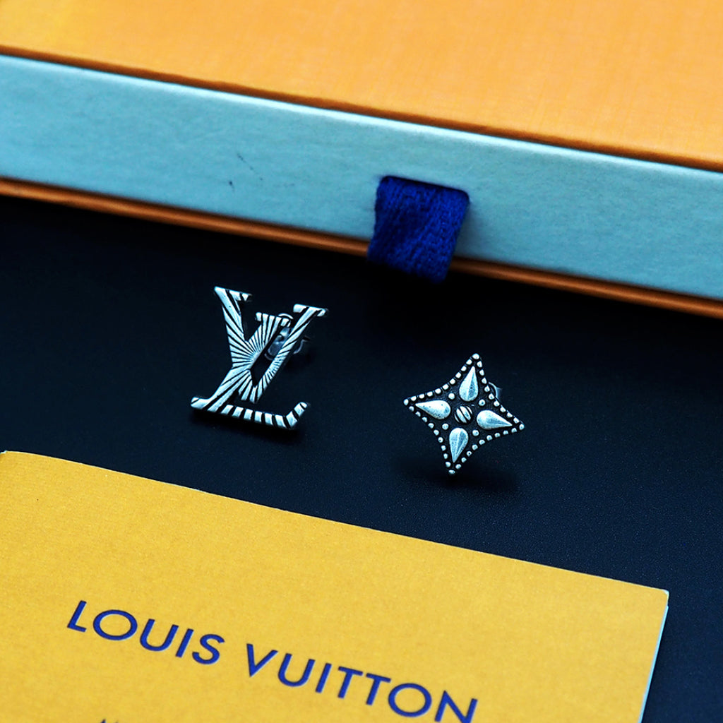 Louis Vuitton accessories: silver stud earrings on navy card with blue ribbon