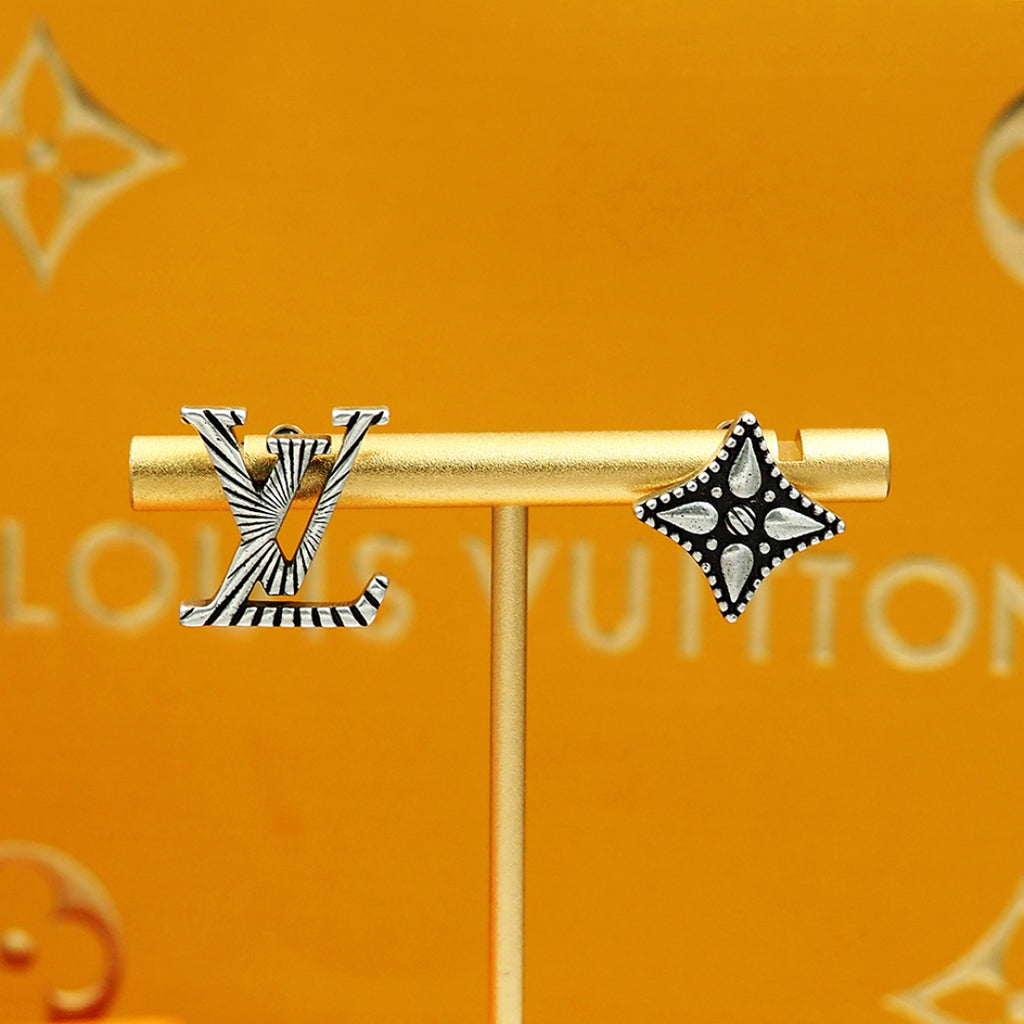 Louis Vuitton accessories: silver LV monogram and star stud earrings on gold bar