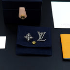 Louis Vuitton accessories: silver stud earrings on navy pouch with box and paper