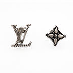 Louis Vuitton accessories: silver star and LV monogram stud earrings, close view