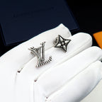 Louis Vuitton accessories: silver stud earrings on white cloth pouch, star and LV