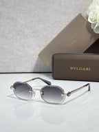 Sunglasses with dark gray lenses and silver metal frame, angular brow