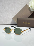 Sunglasses with green tinted lenses and dark frame, gold-tone temple ornaments