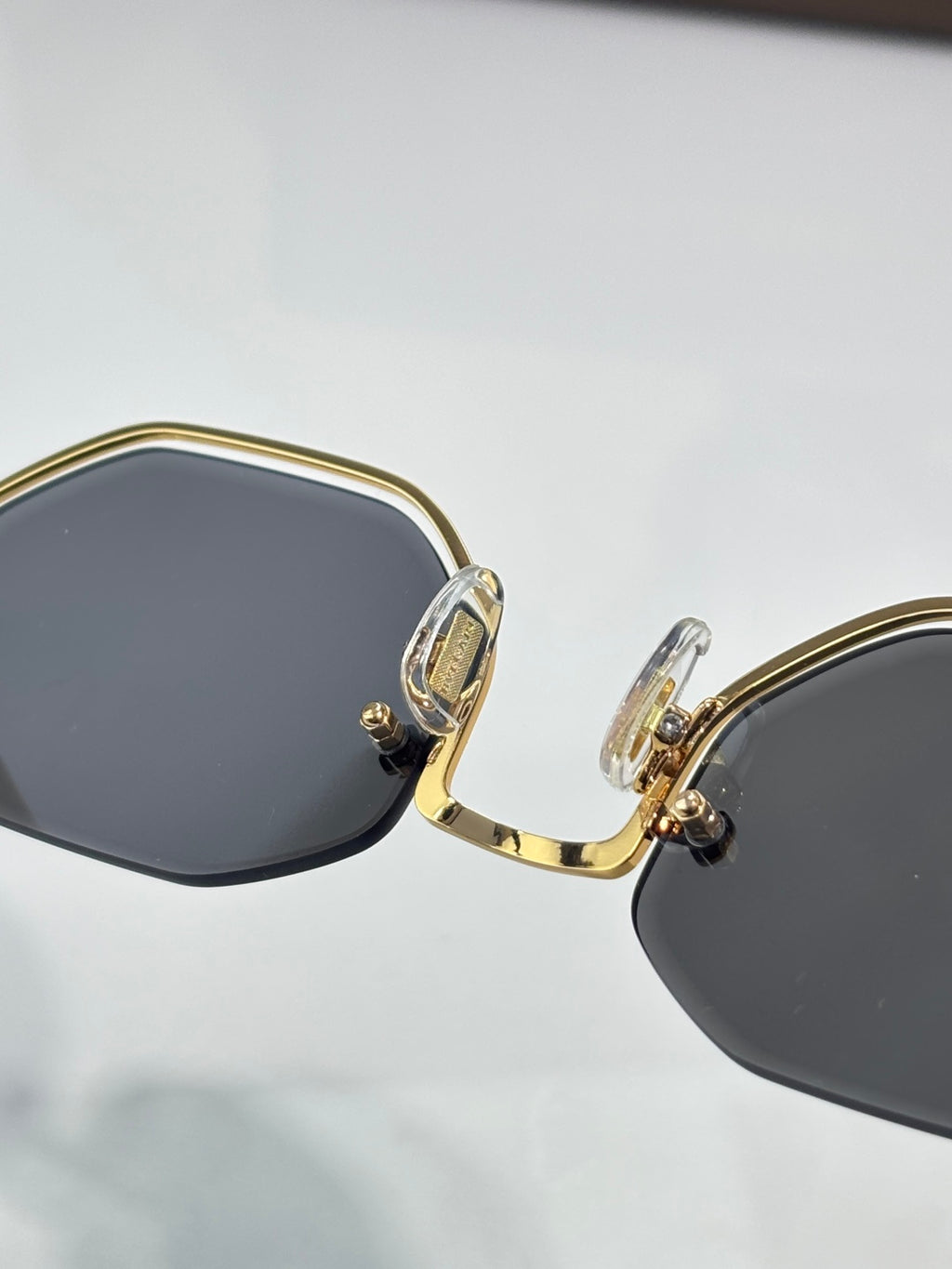 Octagonal sunglasses with gold hinge and dark gray lenses