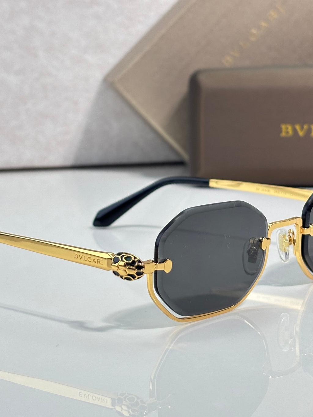 Gold-tone octagonal sunglasses with dark lenses and black temple arms