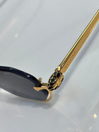 Gold temple arm with printed branding and black lens frame