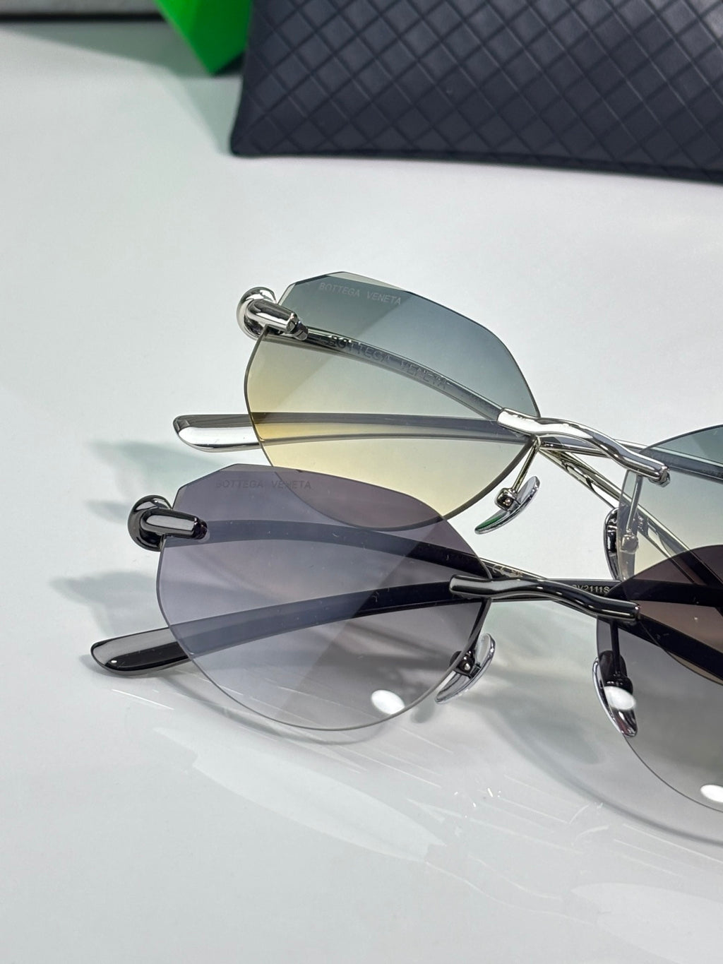 Bottega Veneta sunglasses close-up with smoke gray lenses and black metal frame