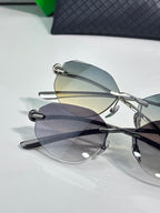 Bottega Veneta sunglasses close-up with smoke gray lenses and black metal frame