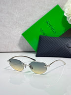 Bottega Veneta sunglasses with light amber lenses and dark frame, oval pilot style