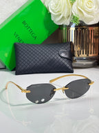 Bottega Veneta sunglasses with dark lenses and gold frame, oval pilot silhouette