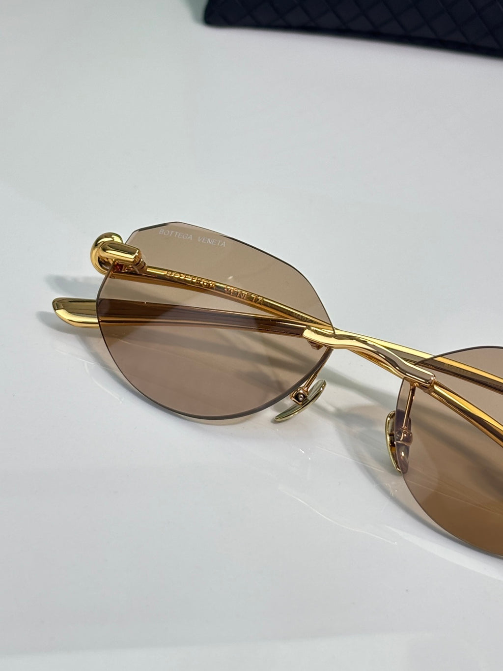 Bottega Veneta gold-tone glasses with brown lenses, angled close-up