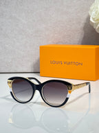 Sunglasses with black round frames, gold-tone accents, and tinted lenses