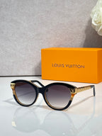 Sunglasses with black round frames and gold-tone temple accents with dark lenses