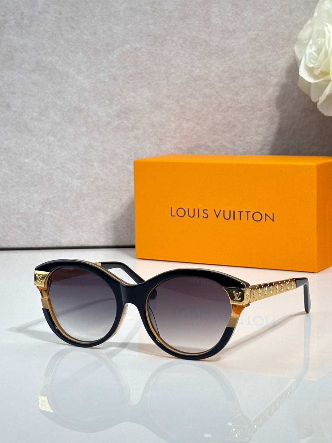 Sunglasses with black round frames and gold-tone temple accents with dark lenses