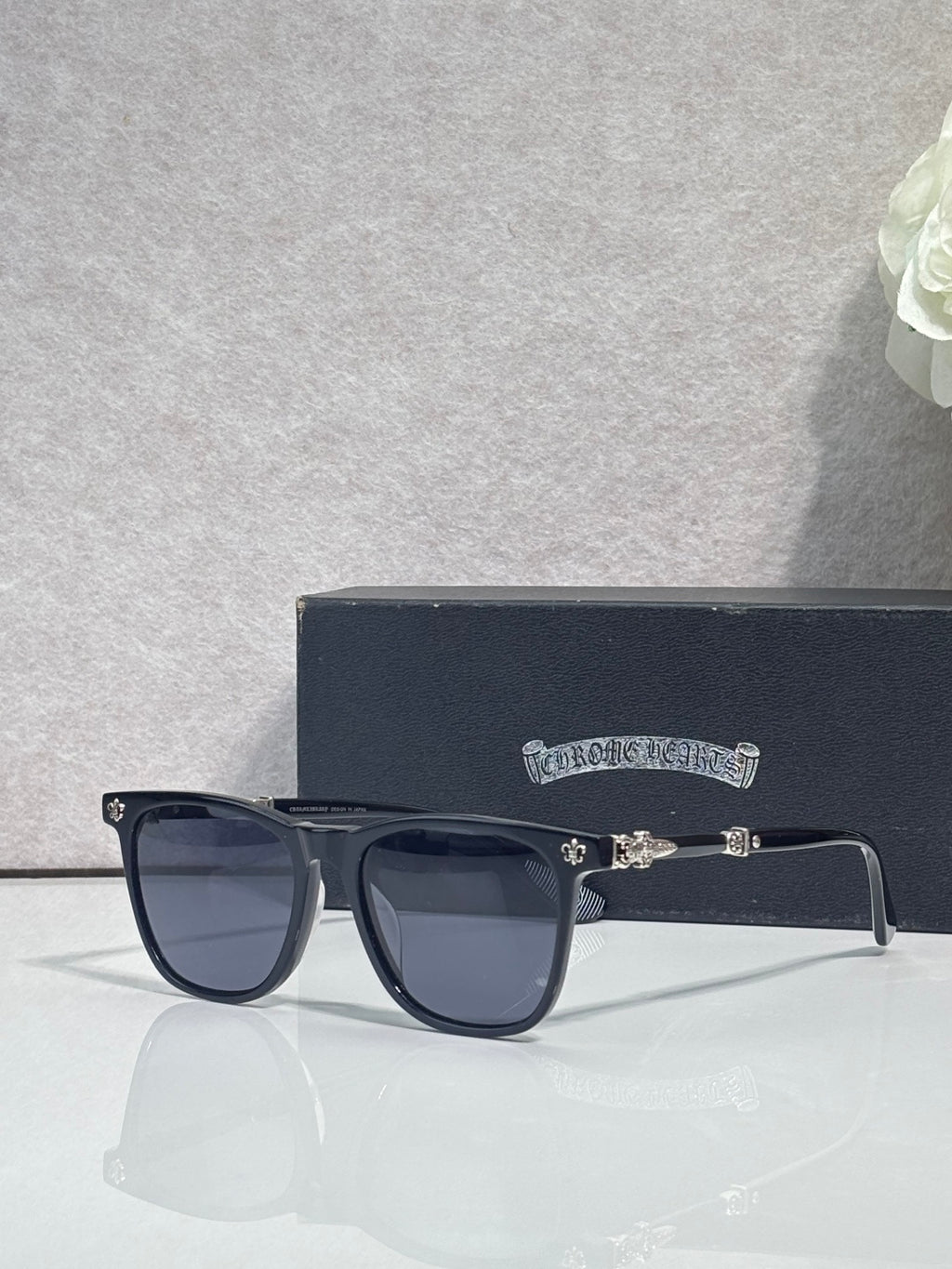 Chrome glasses with dark navy square frames and tinted lenses, metal hinge detail